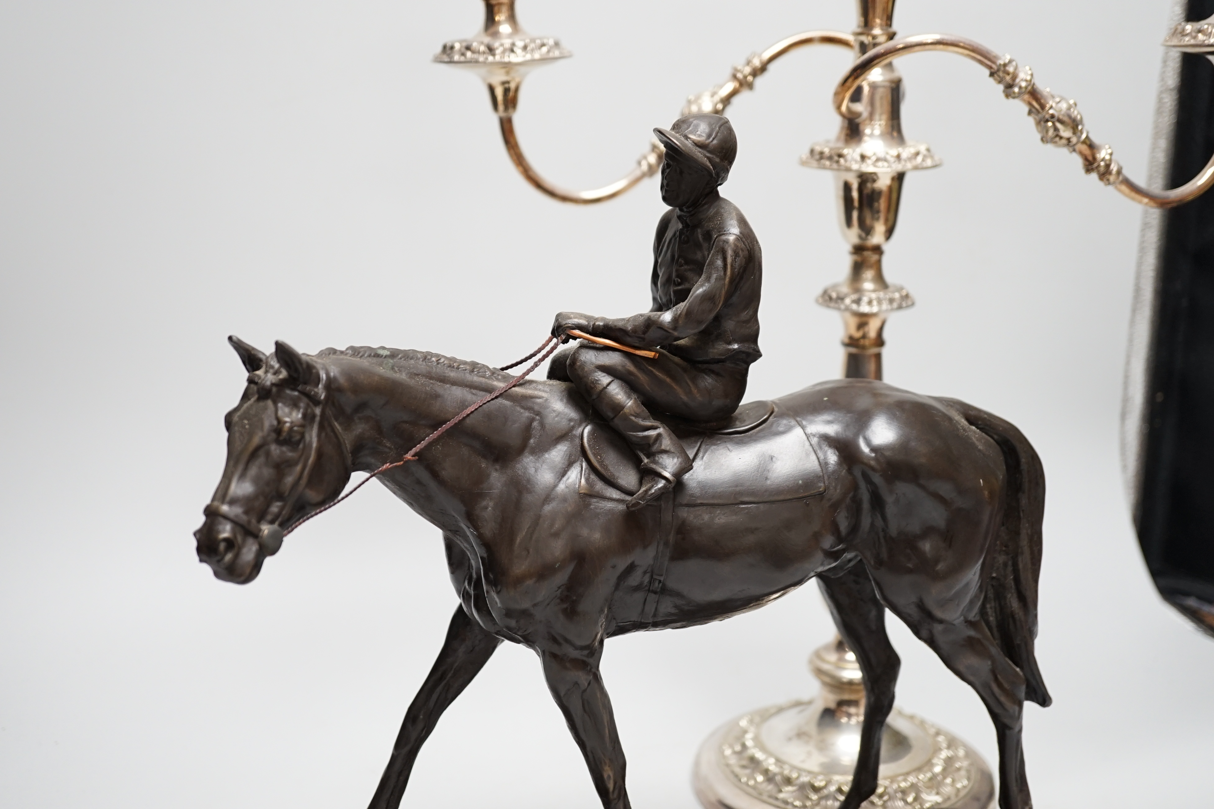A bronzed resin racehorse and jockey group and a silver-plated three branch candelabrum -45cm high